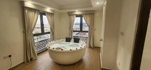 阿可贺巴فندق جولدن ايليت Golden Elite Hotel的带浴缸的大窗户