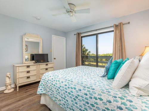 泰比岛Lighthouse Point 20A的一间卧室设有一张带电视和窗户的床。