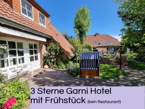 特希尔Hotel Garni Friesenhuus的房屋前方有长凳的院子