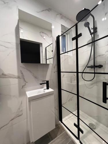 亨顿Star London Finchley Lane 2-Bed Oasis with Garden的白色的浴室设有水槽和淋浴。