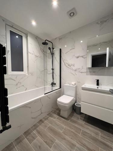 亨顿Star London Finchley Lane 2-Bed Oasis with Garden的浴室配有卫生间、淋浴和盥洗盆。
