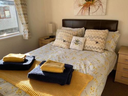维斯贝希Honeybee Lodge的一间卧室配有一张床,上面有两条毛巾