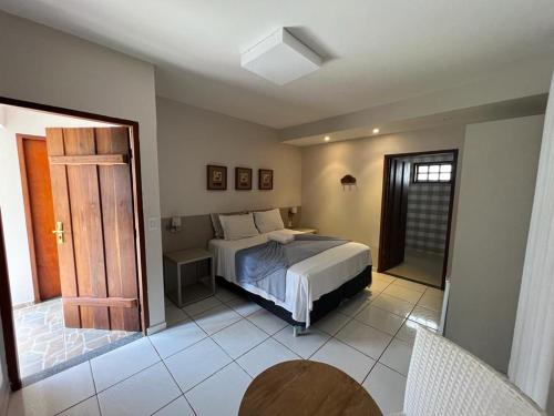 皮雷诺波利斯Pousada Canto do Sabiá - Pirenópolis的一间卧室设有一张床和一个开放式门