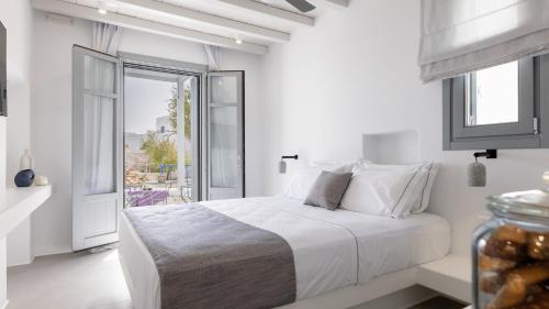 基莫洛斯岛Azure Kimolos的白色的卧室设有床和窗户