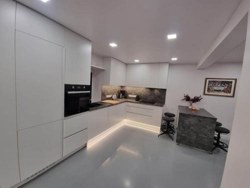 Lakstīgalas的厨房配有白色橱柜和桌子