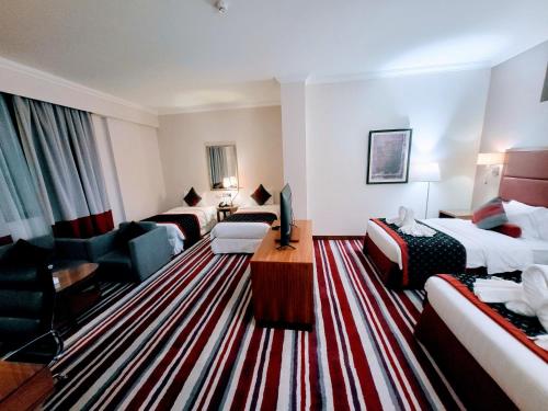多哈Wonder Palace Hotel Qatar的酒店客房带两张床和一个客厅