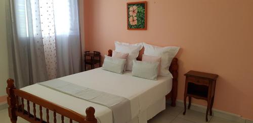 旧阿比唐Paisible maison à Vieux-Habitants的一间卧室配有带白色床单和枕头的床。