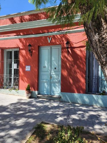 科洛尼亚-德尔萨克拉门托Casa Victoria的前方有蓝色门的红色建筑