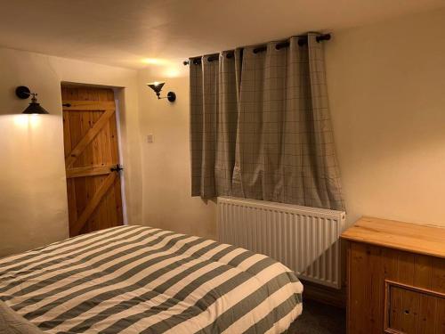 卡斯尔顿The Barn Behind的一间卧室配有床和带窗帘的窗户