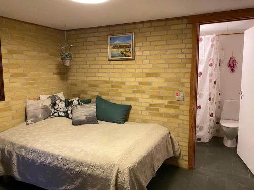 TroenseEskærhus på Tåsinge, tæt på Svendborg - Afdeling med egen indgang的一间卧室设有一张床和砖墙