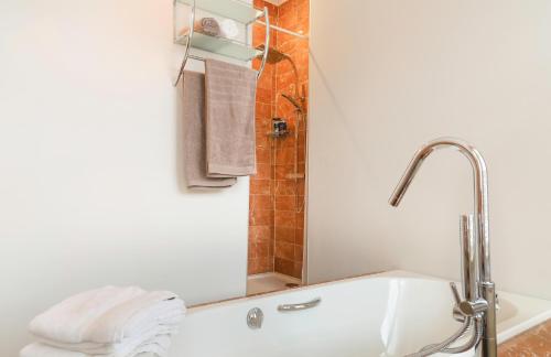 伊普尔Maison Rose的浴室配有浴缸、淋浴和毛巾。