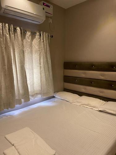 钦奈AVVAIRAM SERVICE APARTMENT G8的一间卧室设有一张大床和窗户