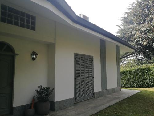 都灵Villa in Precollina的白色房子的一侧有一道黑色门