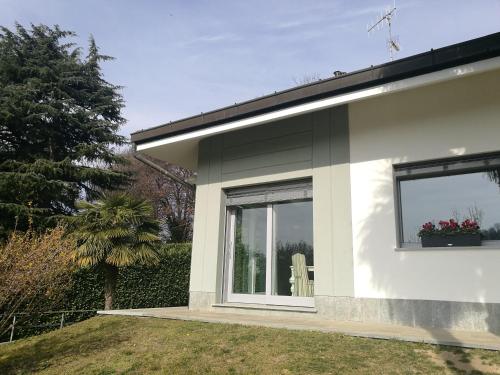 都灵Villa in Precollina的白色的房子,设有两扇窗户和庭院