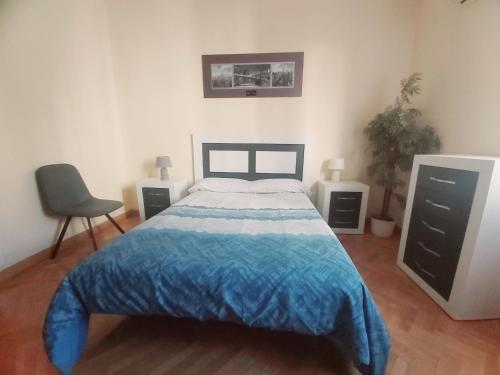 马德里Apartamento en Retiro的一间卧室配有一张床和一把椅子
