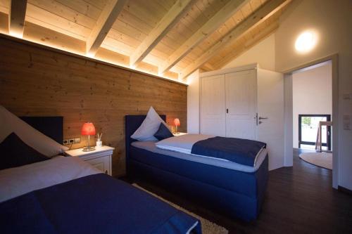 上施陶芬Châlets de la Liberté的一间带两张床铺的卧室,位于带木墙的房间内