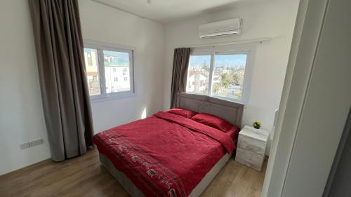 北尼科西亚Tetris Apartment Spacious Comfortable的一间卧室设有红色的床和2个窗户。