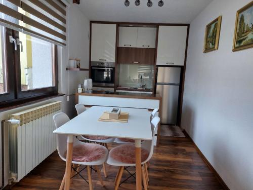 萨拉热窝Apartman Kovaci的小厨房配有白色的桌子和椅子