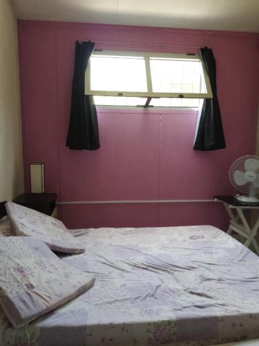 拉帕洛马Casa en Arachania - La Paloma的一间卧室设有一张大床和窗户