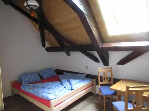 Horní VltaviceChalupa Annenské stráně的卧室配有一张床和一张桌子及椅子