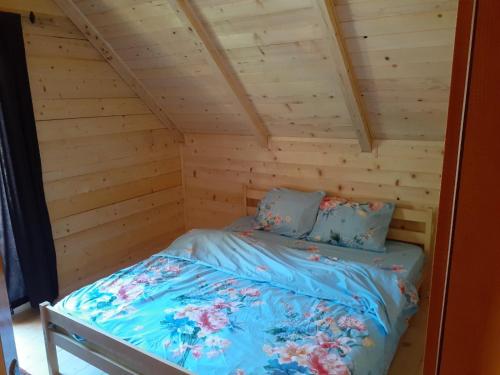 佩奇Villas Meti Rugove的小木屋内的一张床位,配有蓝色床单和枕头