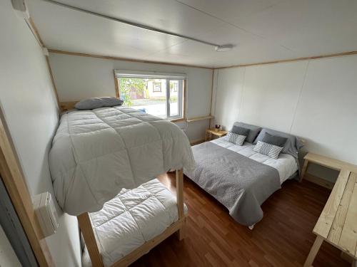 纳塔列斯港Patagonia Sweet Home的一间小卧室,配有两张床和窗户
