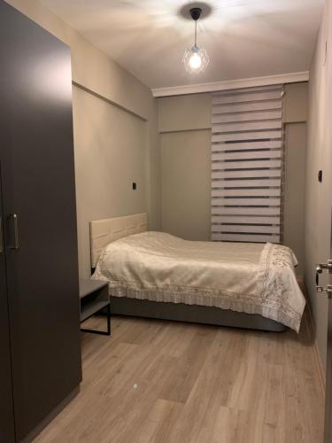 格瑞科勒Lovely Duplex Guesthouse in Bursa的一间卧室设有一张床和一个窗口