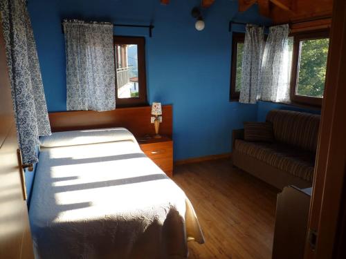 坎加斯-德奥尼斯Vivienda Vacacional La Cantera的卧室拥有蓝色的墙壁,配有一张床和一张沙发