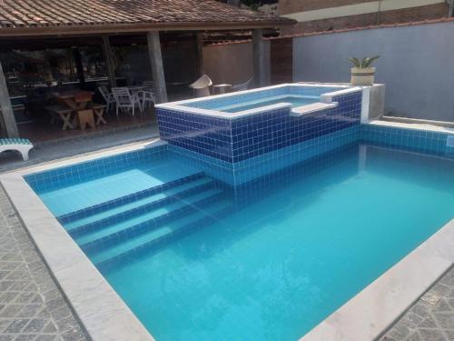 卡拉瓜塔图巴Santa Paula - Cocanha - De frente para a Praia的一座蓝色瓷砖的游泳池