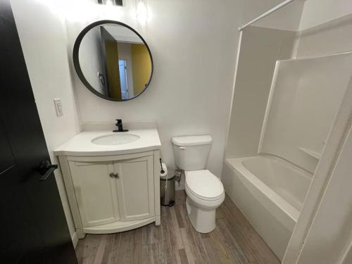 温尼伯Home away from home的白色的浴室设有卫生间和镜子