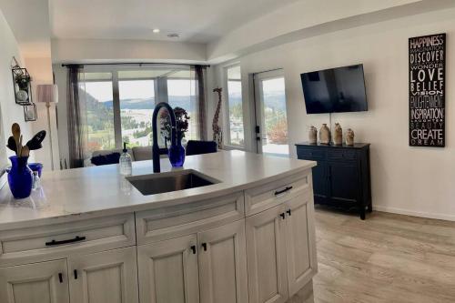基洛纳Black Mountain Amazing Home on Golf Course的一个带水槽的厨房和客房内的电视