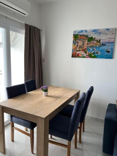 北尼科西亚Tetris Apartment Spacious Comfortable的一张带蓝色椅子和绘画的餐桌