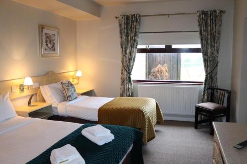阿马山景旅馆的酒店客房设有两张床和窗户。