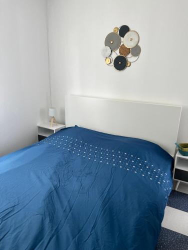 塞纳河畔维尼厄Belle maison的卧室配有蓝色的床,墙上挂着时钟