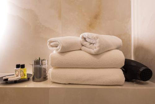 萨拉热窝Apartments EMERALD Free Garage Parking的浴室桌子上摆放着一堆毛巾