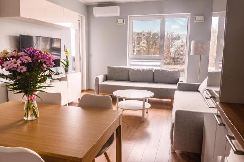 华沙Marywilska apartment的客厅配有沙发和桌子