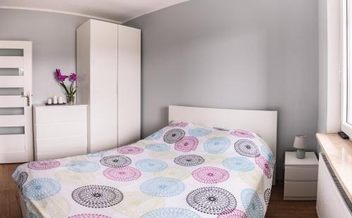 华沙Marywilska apartment的一间卧室配有一张带波卡圆床罩的床。