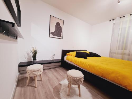 戈尔多拉Casa Rosina - Una caramella, nel nucleo, ai piedi della Verzasca-的一间卧室配有一张黄色的床和两张凳子