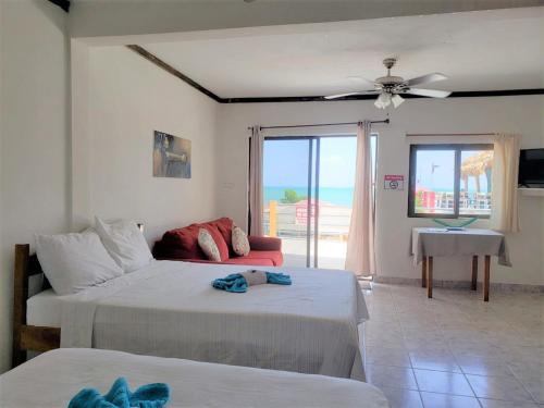库尔克岛Beach Side Condos Caye Caulker by CCVH的一间带两张床的卧室和一间客厅