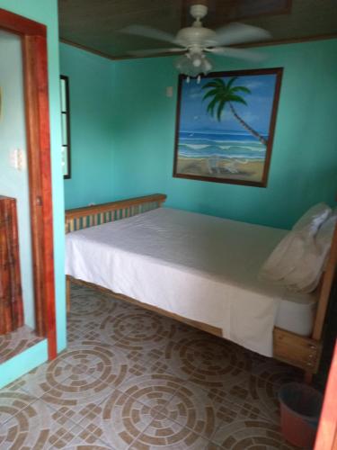大玉米岛Hospedaje Rosa Del Mar的一间设有一张蓝色墙壁床铺的卧室