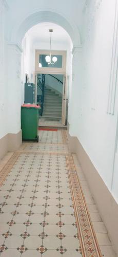 维也纳Standard Apartment 5P TH的一条空的走廊,铺着瓷砖地板,设有楼梯