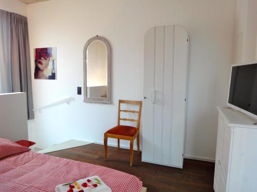 科隆科隆乡村公寓的一间卧室配有一张床、一把椅子和镜子