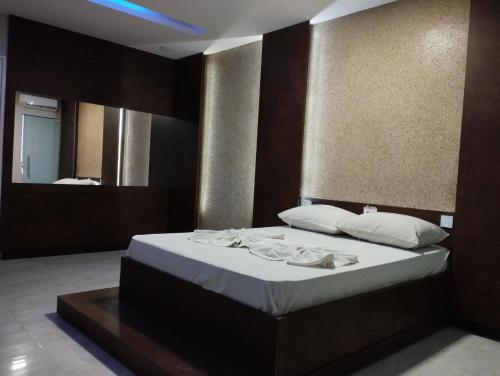 阿拉卡茹Motel FLEX LOVE LAMARAO的一间卧室配有一张带白色床单和镜子的床