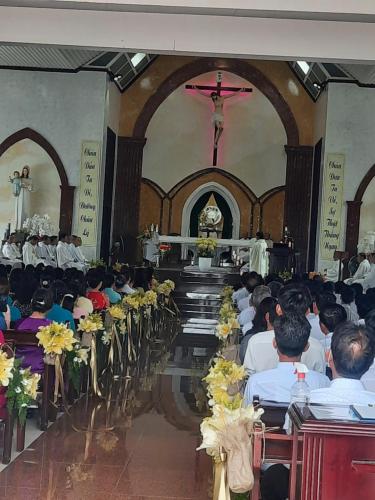 头顿Nhà Nghỉ An Toàn的一群人坐在教堂里,有十字架