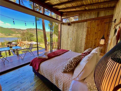 苏埃斯卡Alma de Campo Glamping - Laguna de Suesca的一间卧室配有一张床,阳台配有桌子