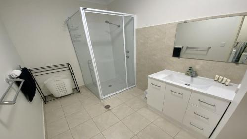 朱里恩湾Unit 48 Seafront Estate的带淋浴和盥洗盆的白色浴室