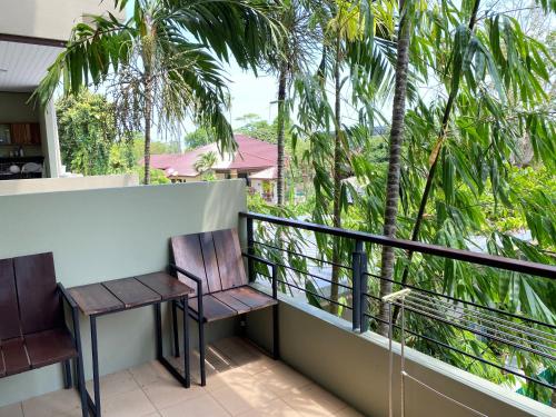拉威海滩本加玛斯普雷斯酒店的阳台配有两把椅子和棕榈树