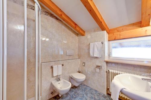 梅拉诺布伦纳酒店的一间带卫生间、水槽和窗户的浴室