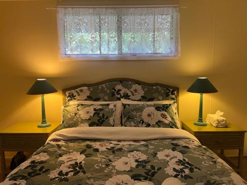 春溪English Gardens - Forest Spa Suite的一间卧室配有一张带两盏灯的床和一扇窗户。