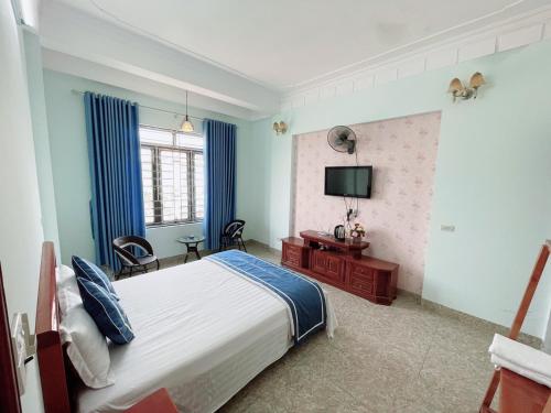 宁平Tam Coc Guest House & Hostel的一间卧室配有一张床和一台电视。